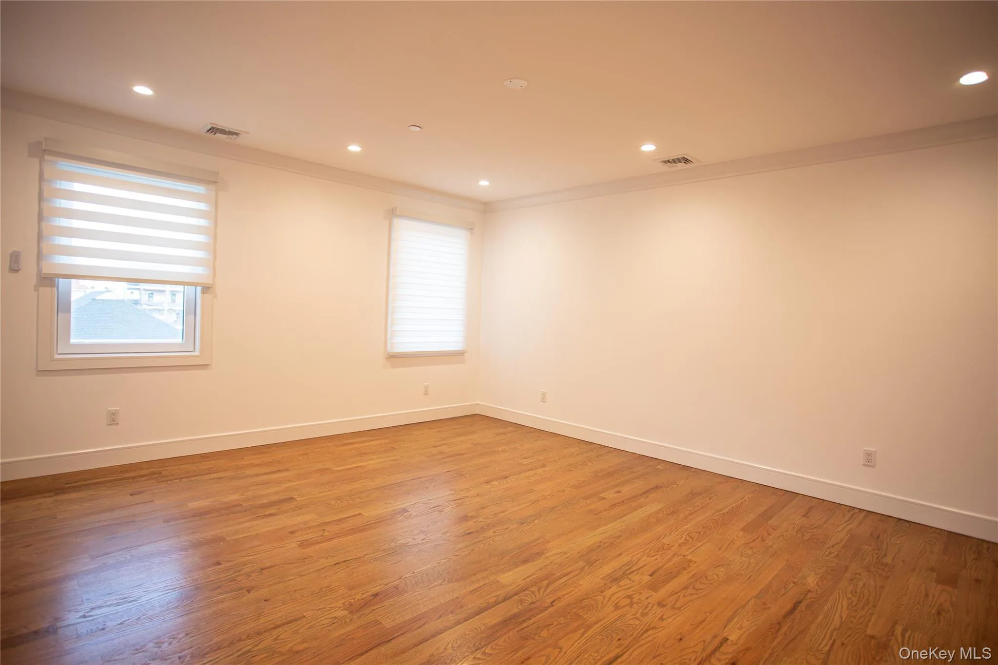 Spare room with light wood-style flooring, ornamental molding, and recessed lighting Spare room with light wood-style flooring, ornamental molding, and recessed lighting