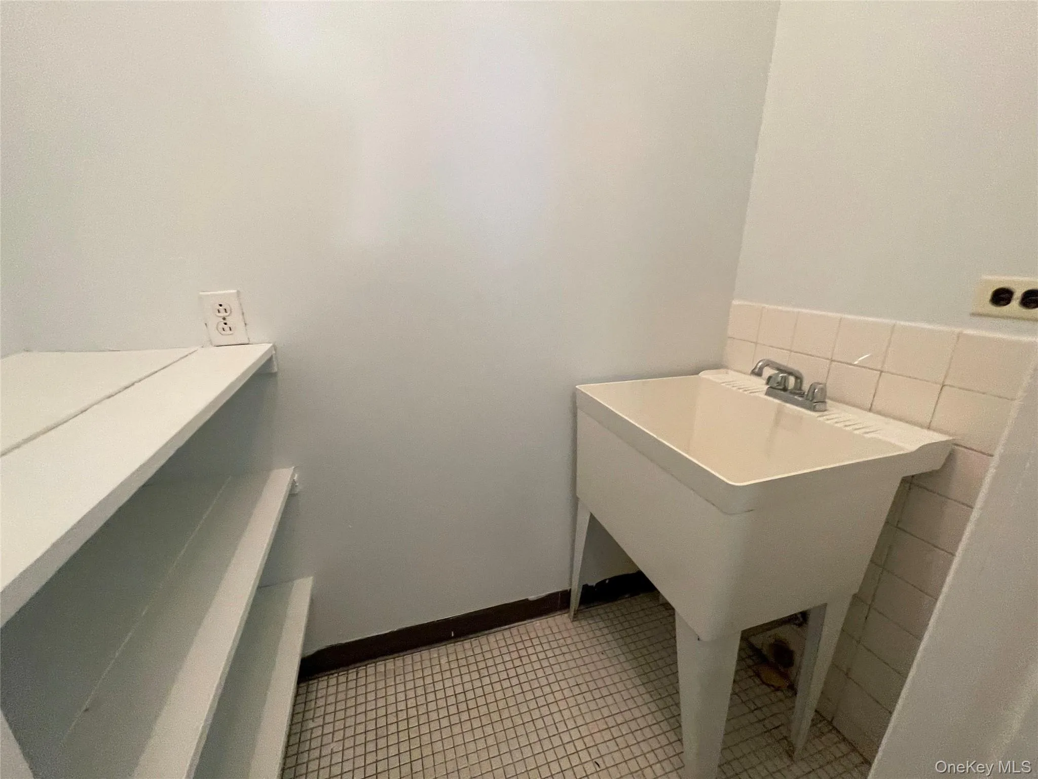 Washroom with light tile patterned floors and tile walls Washroom with light tile patterned floors and tile walls