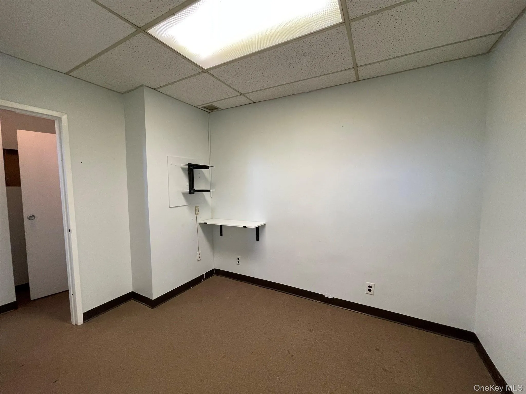 Laundry room featuring dark colored carpet and a drop ceiling Laundry room featuring dark colored carpet and a drop ceiling