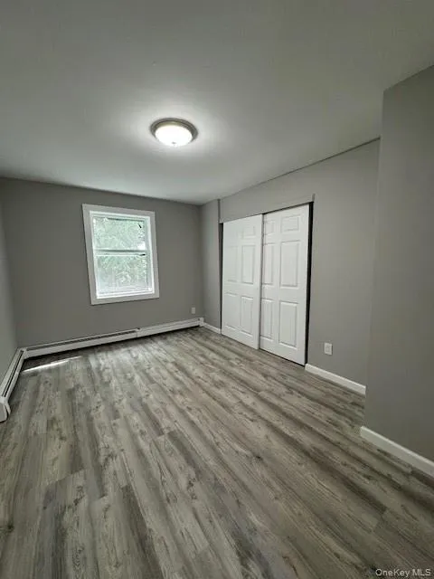 Unfurnished bedroom featuring hardwood / wood-style flooring and a closet Unfurnished bedroom featuring hardwood / wood-style flooring and a closet