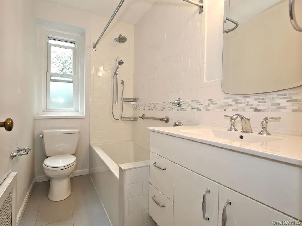 Bathroom with vanity, shower combination, and light tile patterned floors Bathroom with vanity, shower combination, and light tile patterned floors