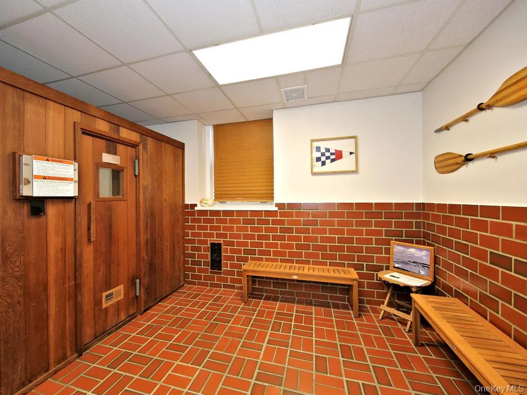 Misc room featuring a wainscoted wall, a drop ceiling, and wood walls Misc room featuring a wainscoted wall, a drop ceiling, and wood walls