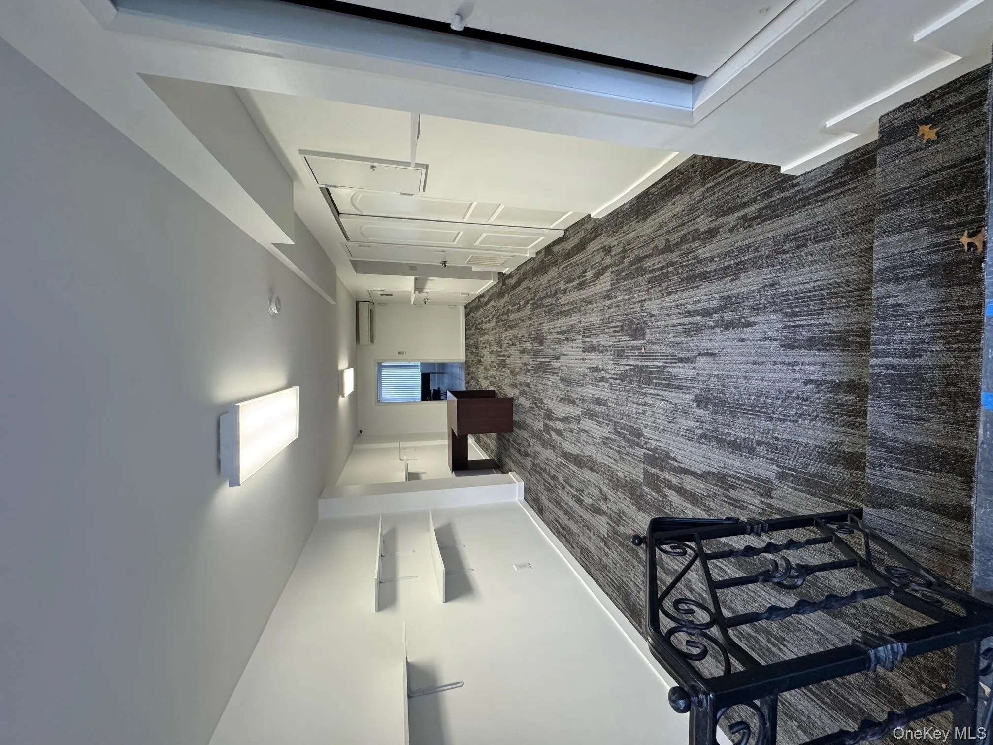 Below grade area with dark carpet and a wall mounted air conditioner Below grade area with dark carpet and a wall mounted air conditioner