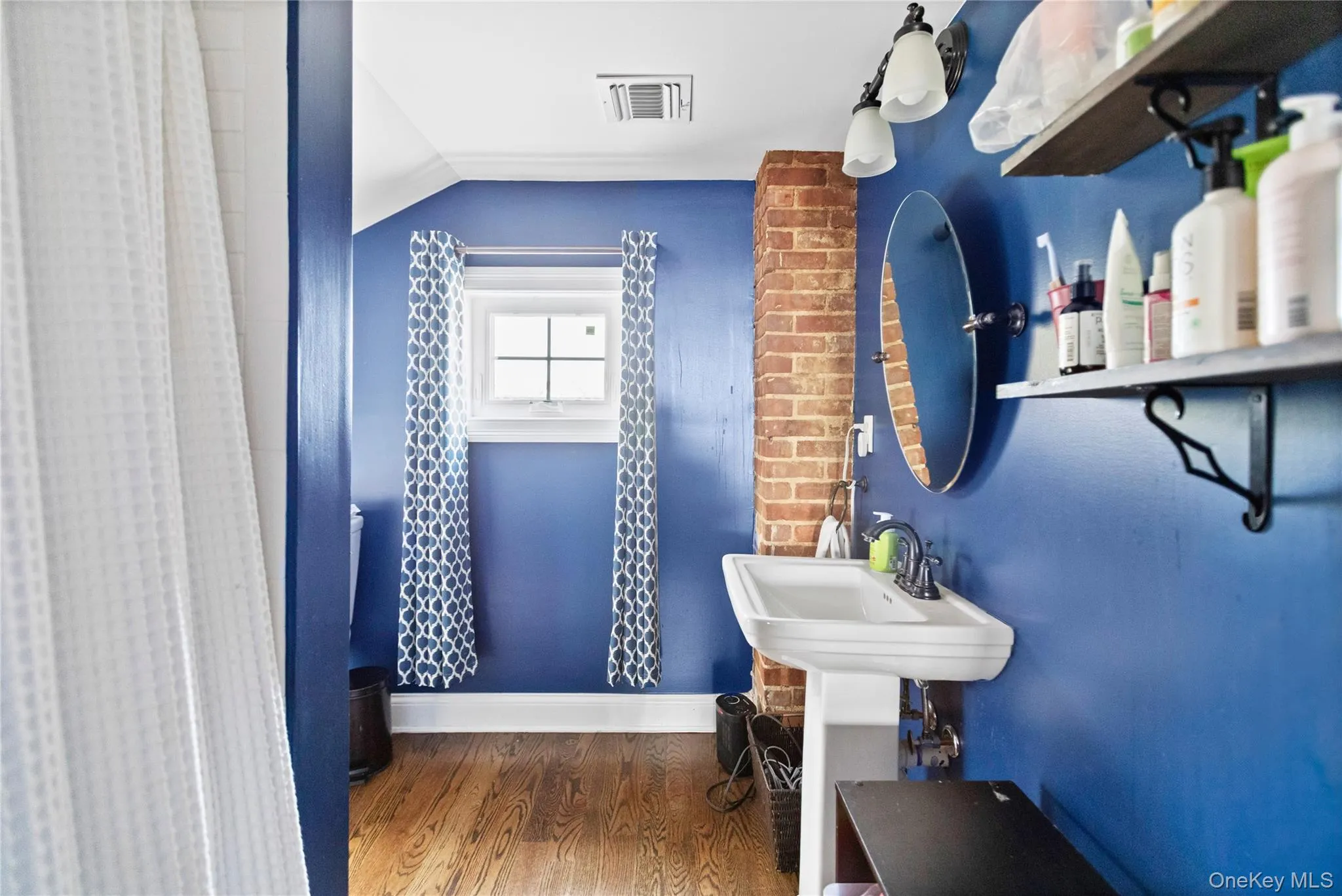 Bathroom with dark wood-type flooring, vaulted ceiling, and curtained shower Bathroom with dark wood-type flooring, vaulted ceiling, and curtained shower