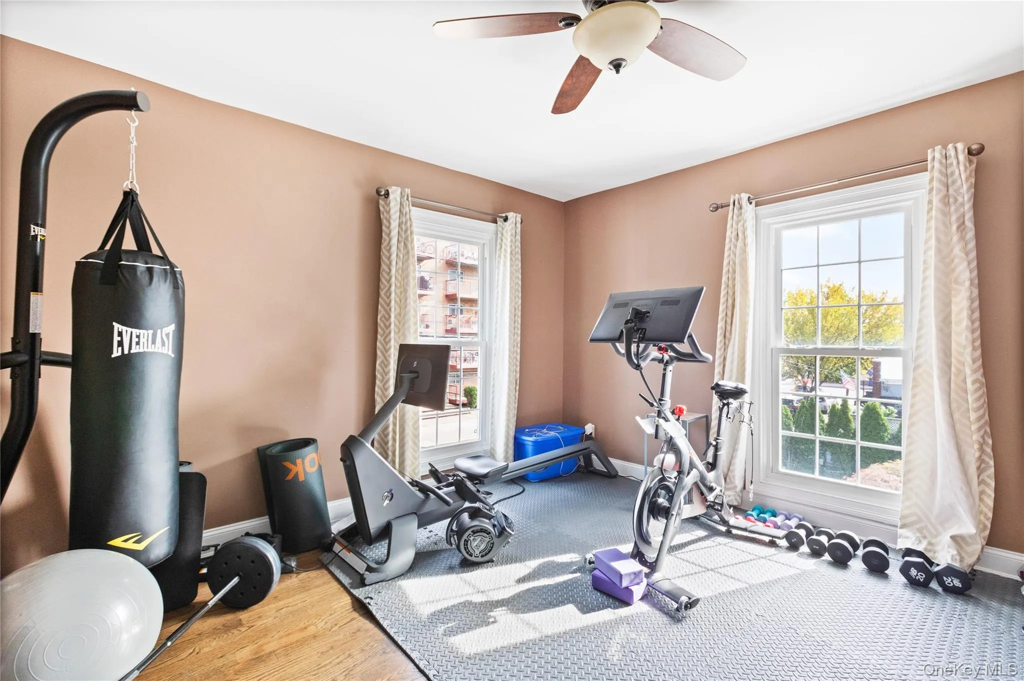 Exercise room with plenty of natural light, wood finished floors, and a ceiling fan Exercise room with plenty of natural light, wood finished floors, and a ceiling fan