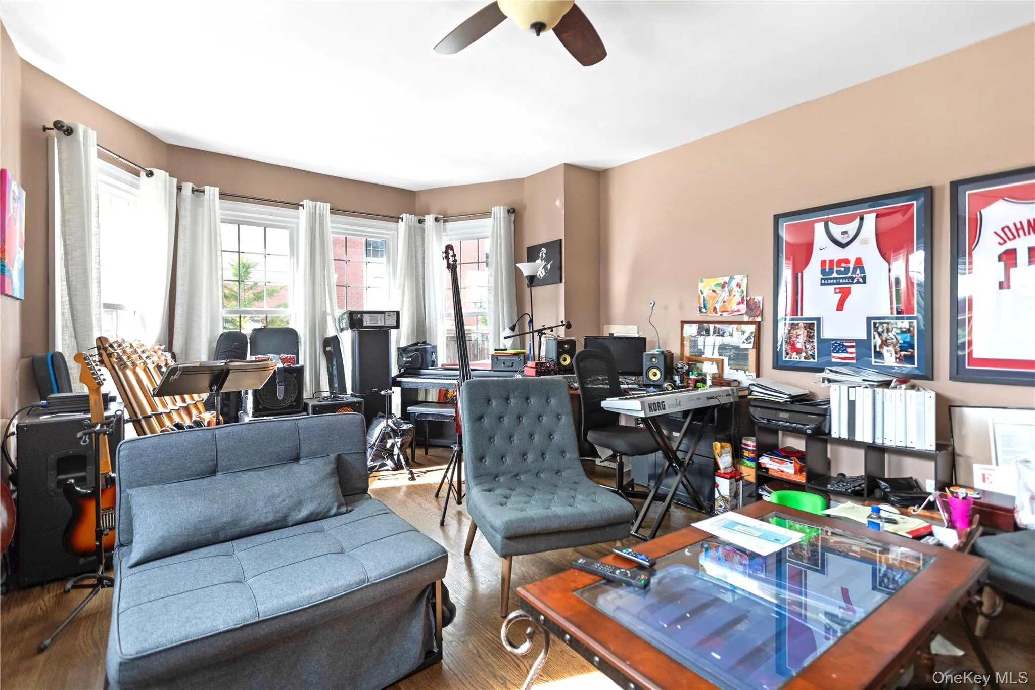 Office area with wood finished floors and a ceiling fan Office area with wood finished floors and a ceiling fan