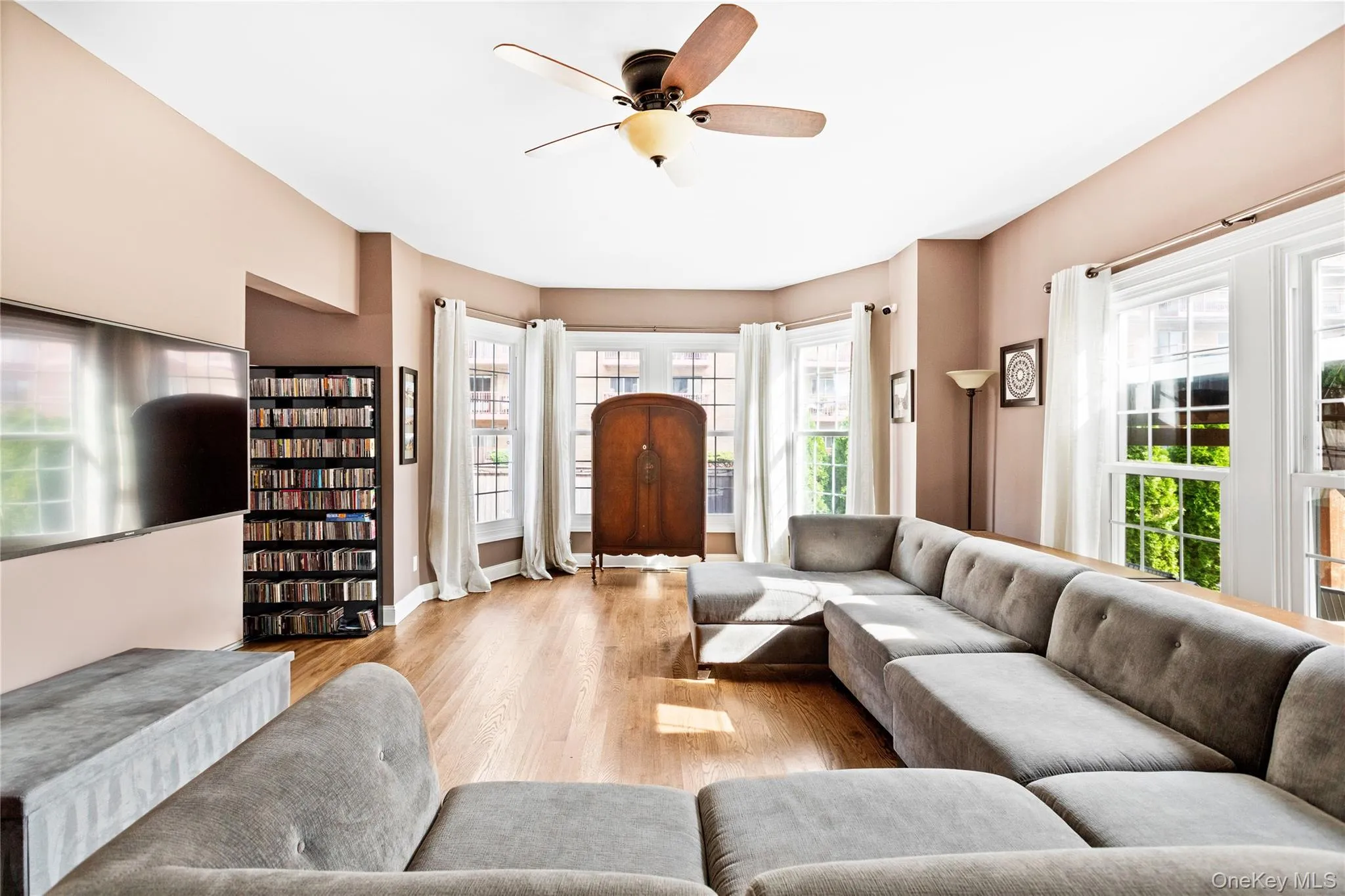Living room with healthy amount of natural light, light wood-type flooring, and ceiling fan Living room with healthy amount of natural light, light wood-type flooring, and ceiling fan