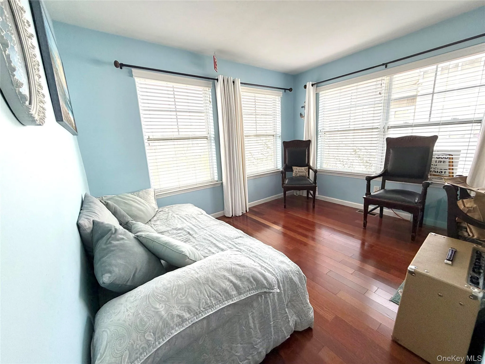Bedroom featuring dark wood-style floors and baseboards Bedroom featuring dark wood-style floors and baseboards