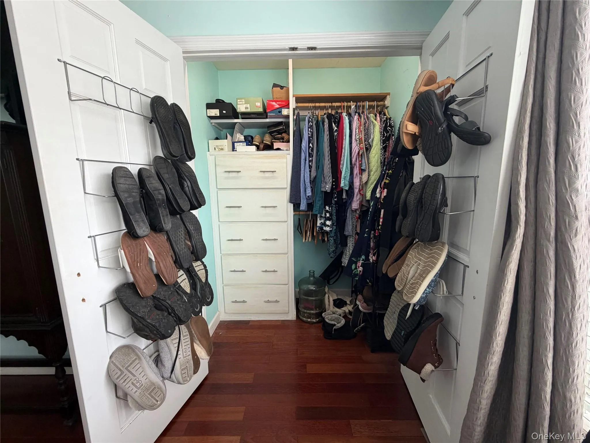 Walk in closet with dark wood-style floors Walk in closet with dark wood-style floors