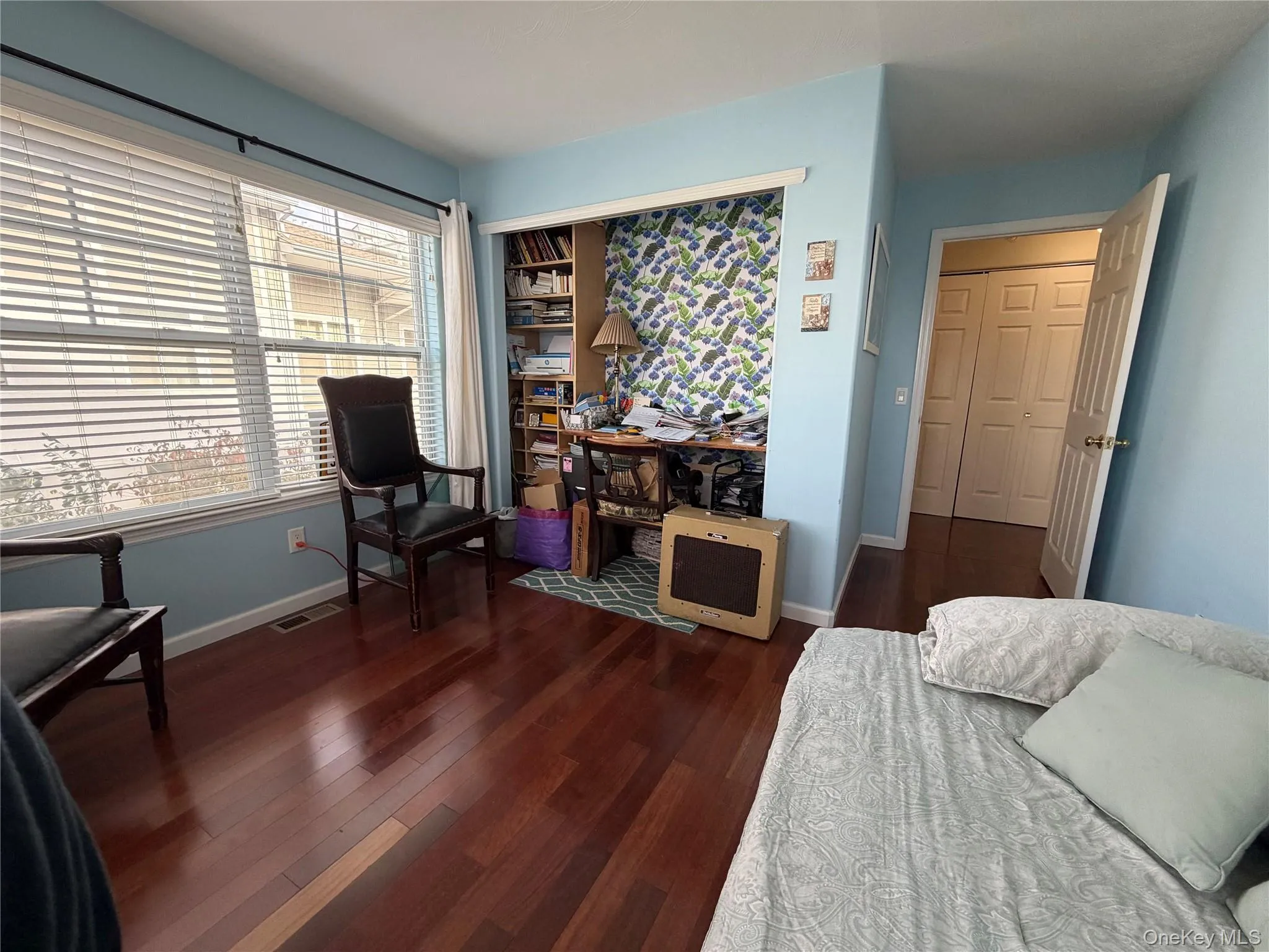 Bedroom with dark wood finished floors and baseboards Bedroom with dark wood finished floors and baseboards