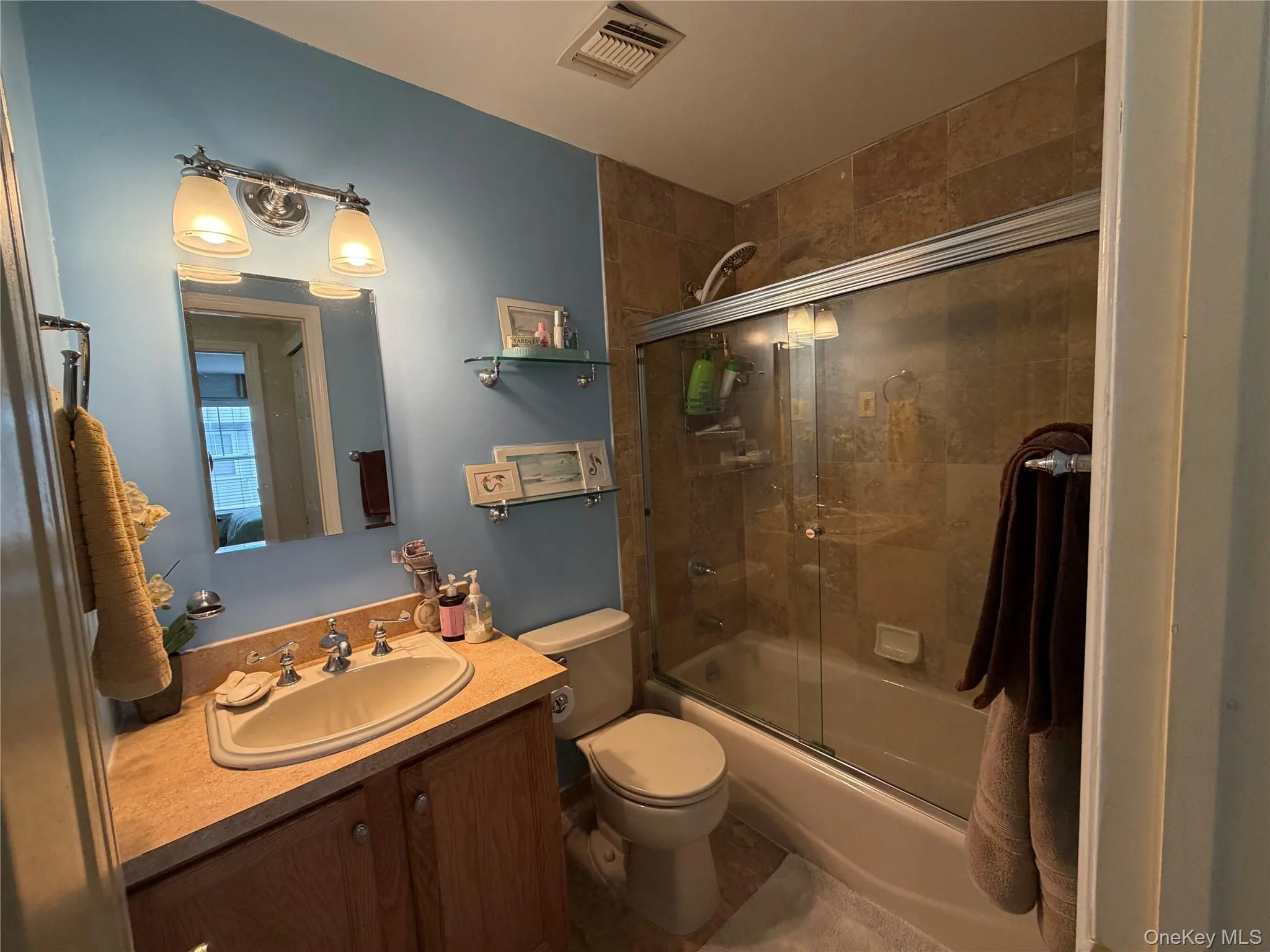 Full bathroom with combined bath / shower with glass door and vanity Full bathroom with combined bath / shower with glass door and vanity