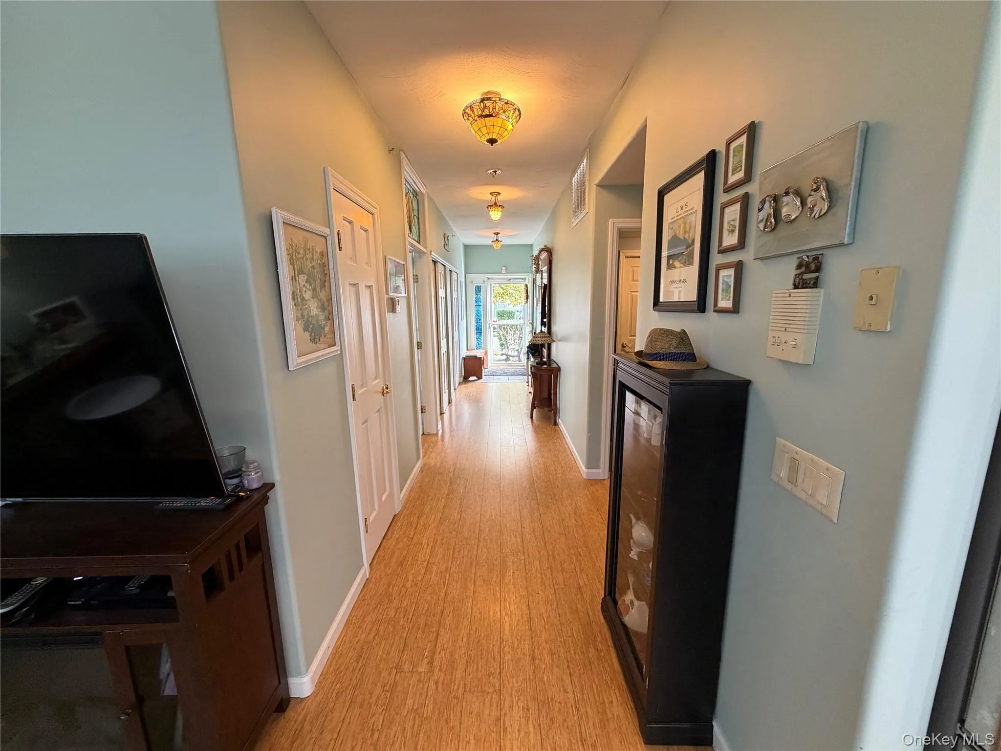 Hallway featuring light wood-type flooring and baseboards Hallway featuring light wood-type flooring and baseboards