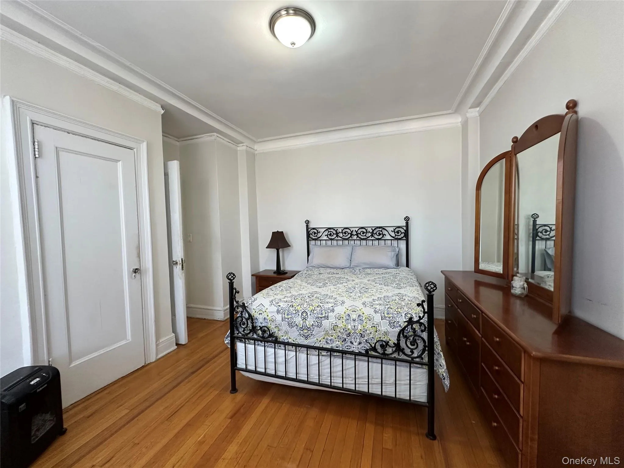 Bedroom with wood finished floors, crown molding, and baseboards Bedroom with wood finished floors, crown molding, and baseboards