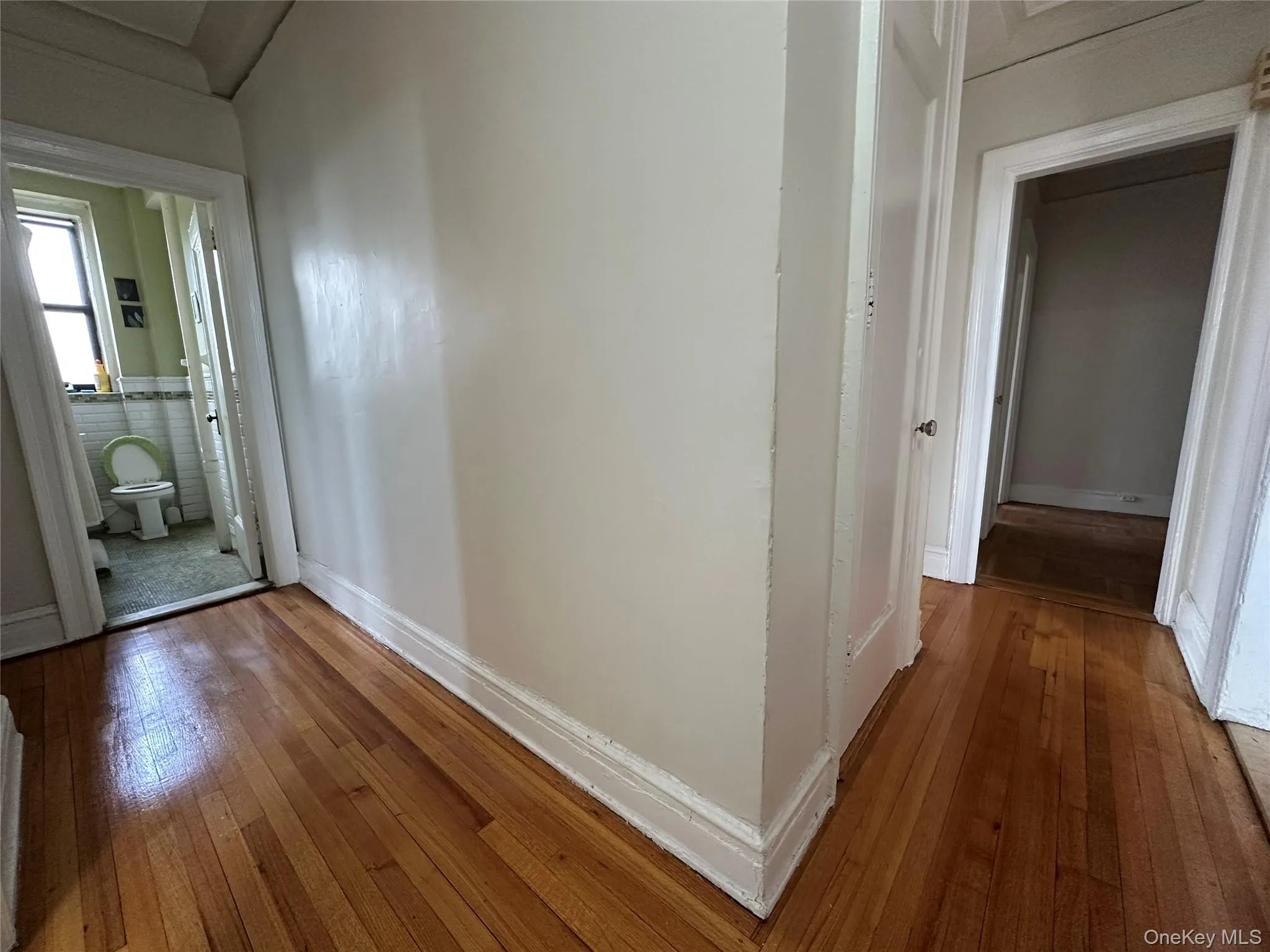 Hall with hardwood / wood-style flooring and baseboards Hall with hardwood / wood-style flooring and baseboards