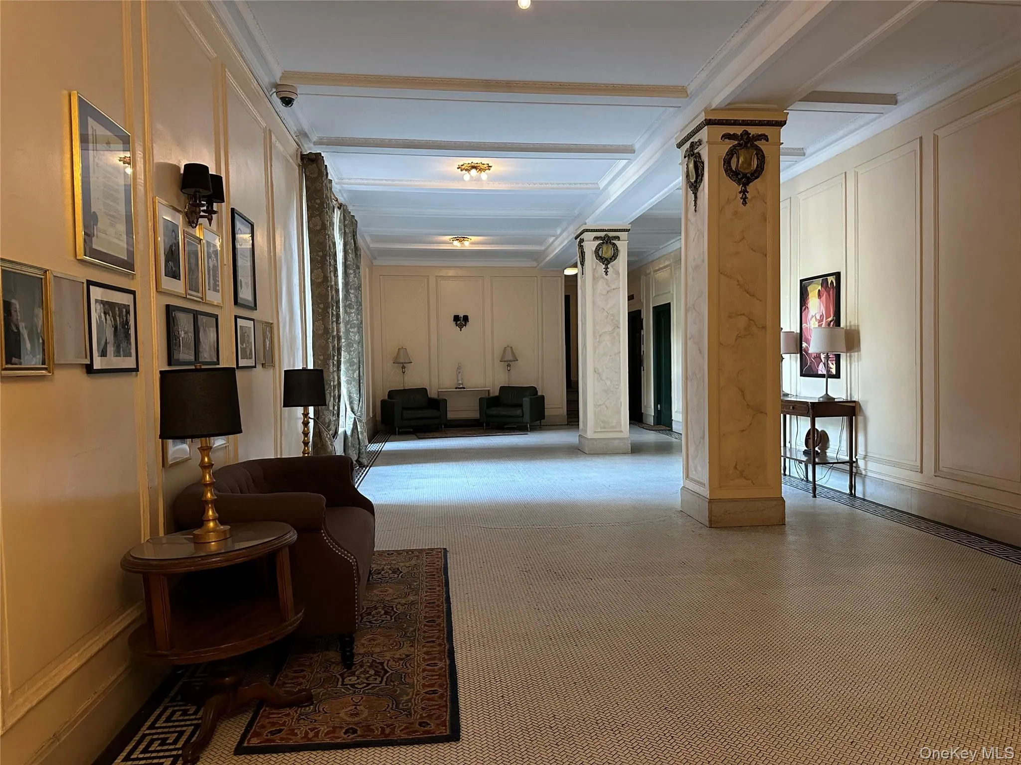Community lobby with a decorative wall, beamed ceiling, a surveillance system, and crown molding Community lobby with a decorative wall, beamed ceiling, a surveillance system, and crown molding