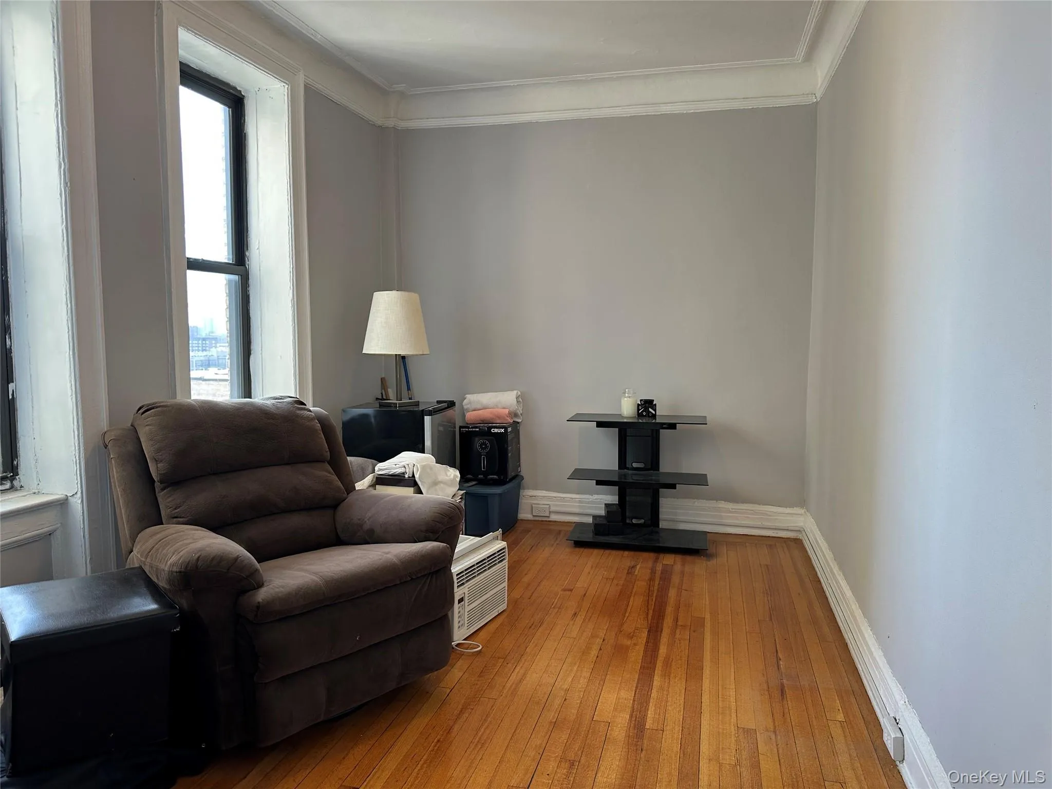 Living area with light wood finished floors, crown molding, and baseboards Living area with light wood finished floors, crown molding, and baseboards