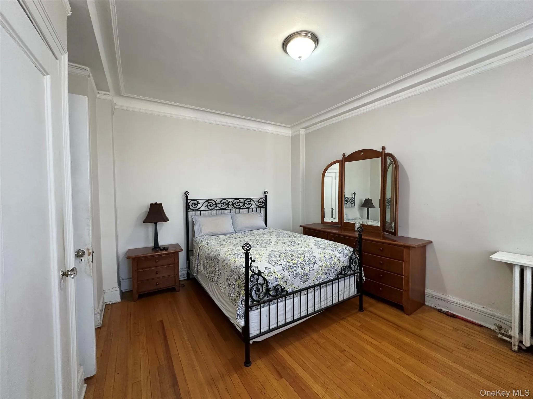 Bedroom with crown molding and wood finished floors Bedroom with crown molding and wood finished floors
