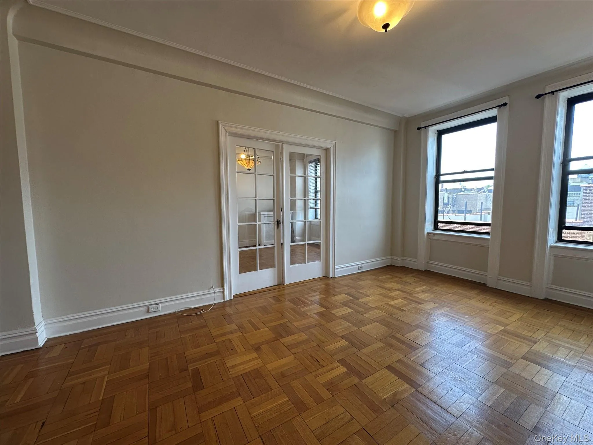 Spare room featuring french doors and baseboards Spare room featuring french doors and baseboards