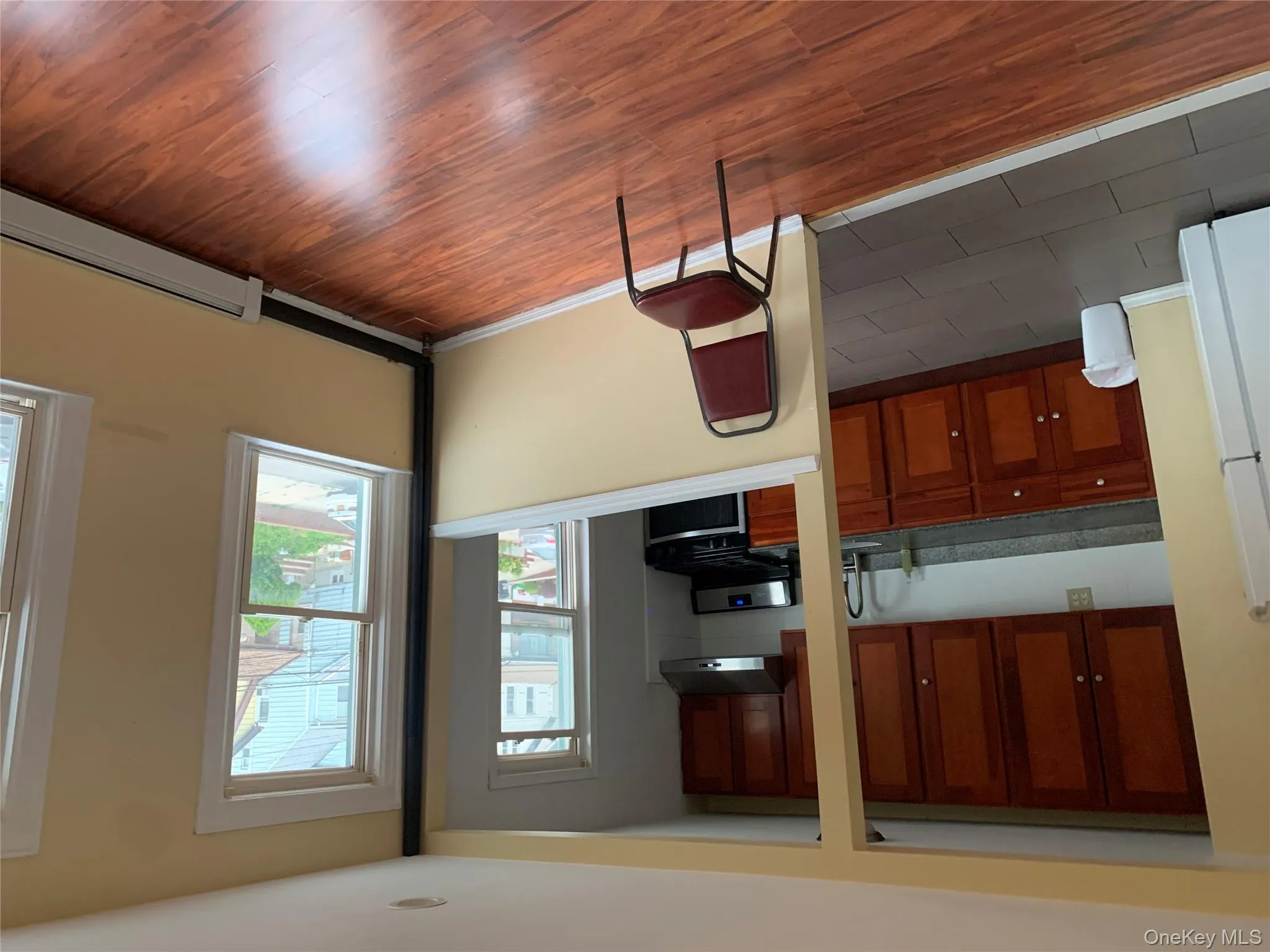 Kitchen with freestanding refrigerator, white stove, brown cabinetry, and dark countertops Kitchen with freestanding refrigerator, white stove, brown cabinetry, and dark countertops