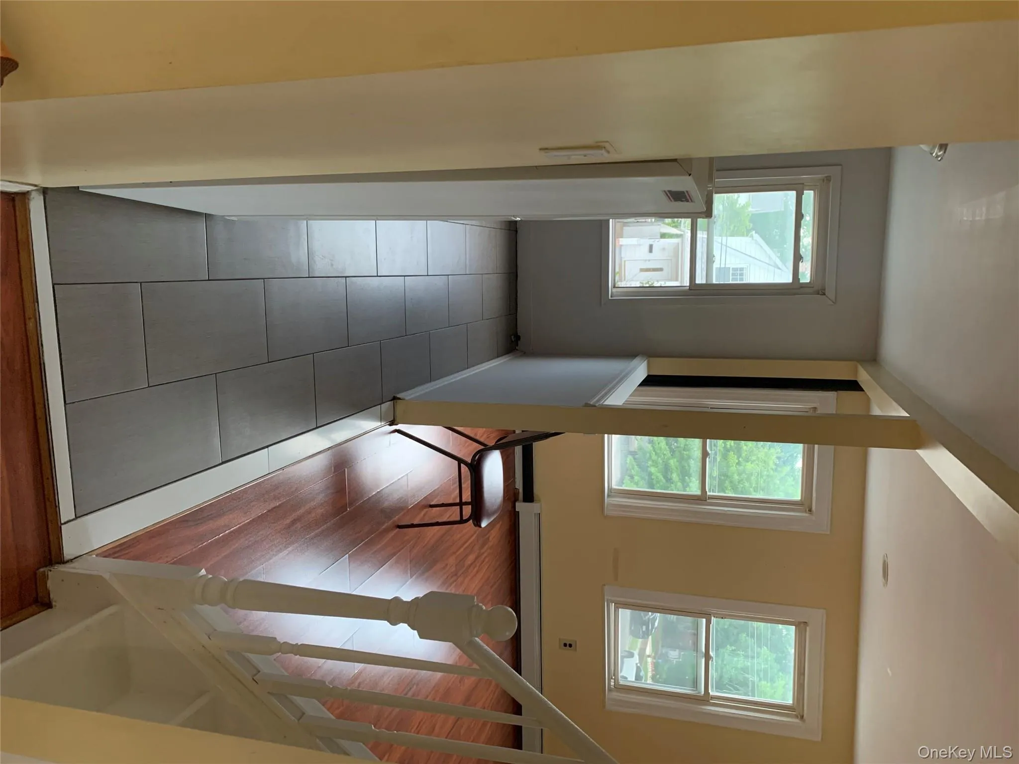 Hall featuring plenty of natural light, baseboard heating, and light tile patterned floors Hall featuring plenty of natural light, baseboard heating, and light tile patterned floors