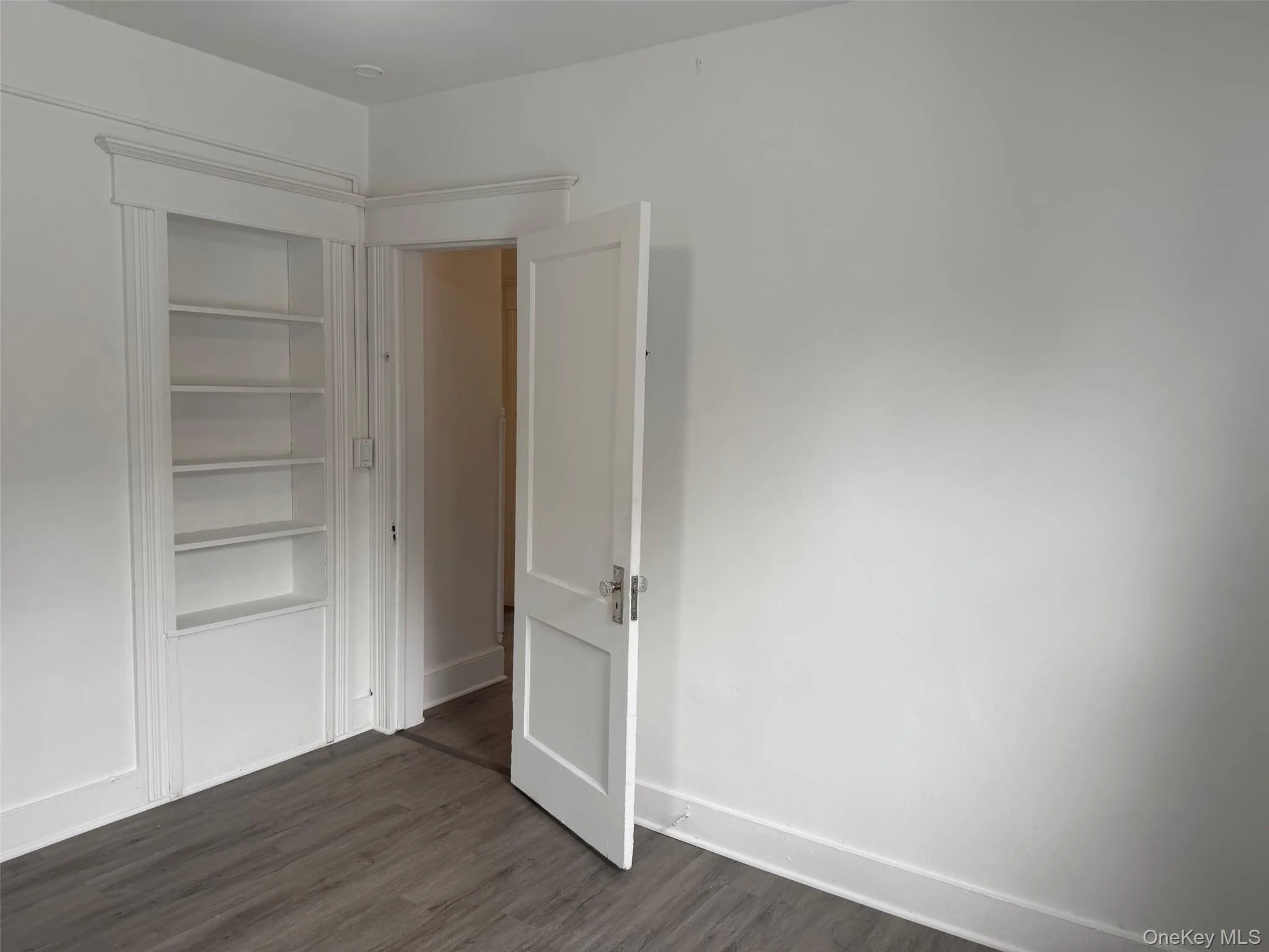 Another angle of Unfurnished bedroom with baseboards and dark wood-style flooring Another angle of Unfurnished bedroom with baseboards and dark wood-style flooring