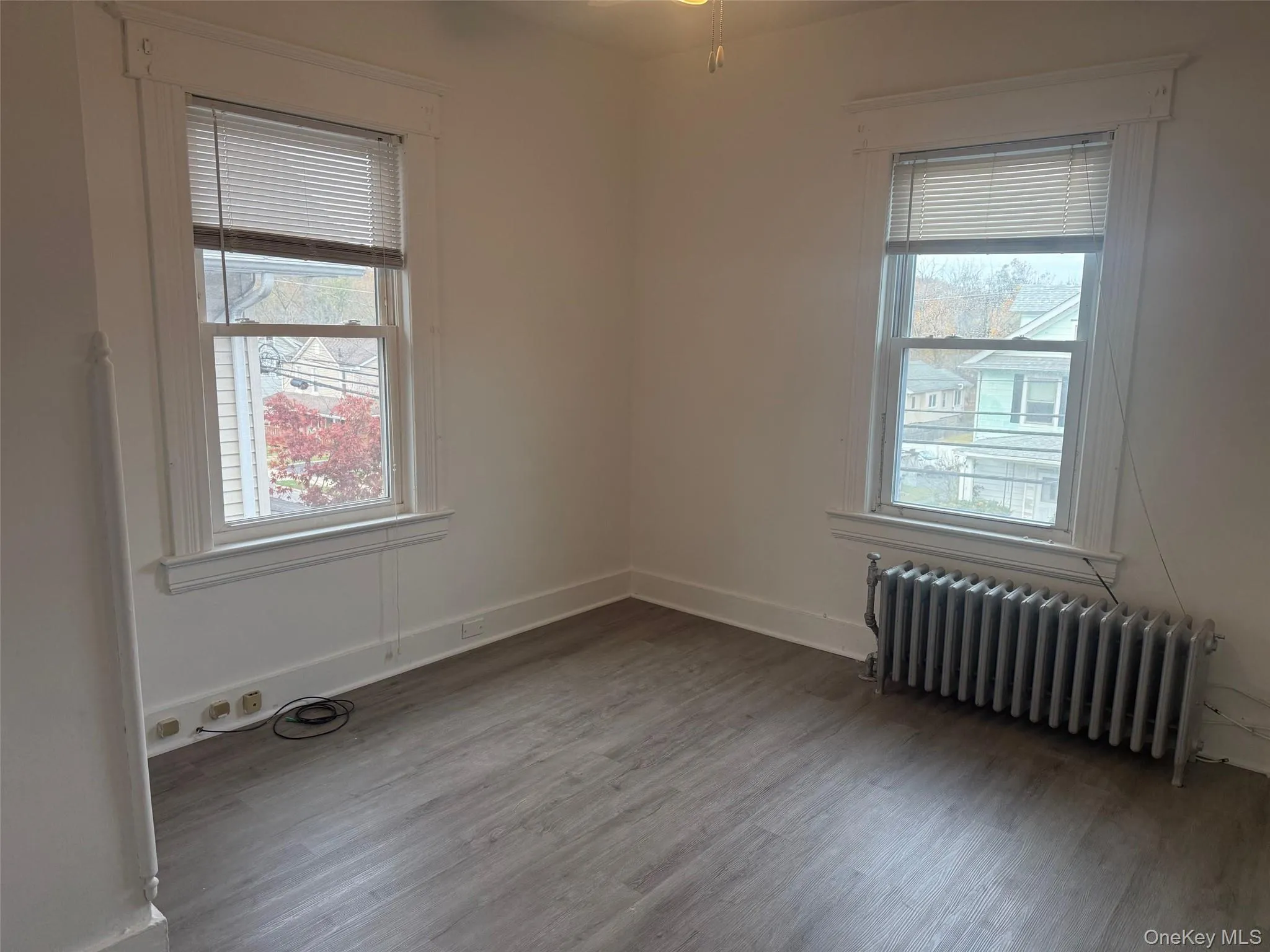 Spare room with radiator heating unit and light wood-style flooring Spare room with radiator heating unit and light wood-style flooring