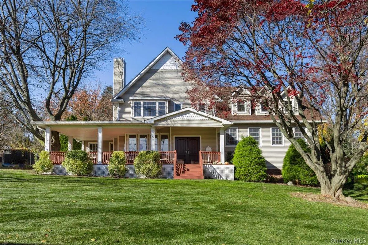 Front of property with large front yard, wrap around deck, and welcoming double french doors Front of property with large front yard, wrap around deck, and welcoming double french doors