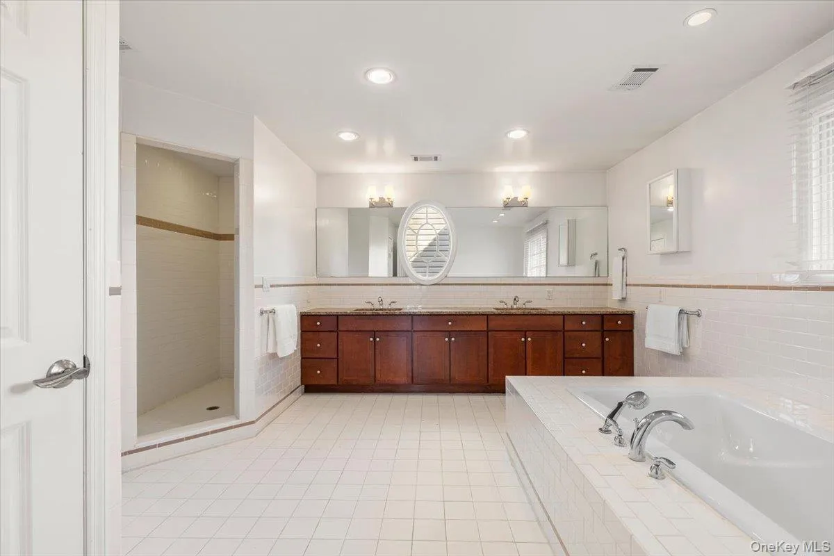 Primary Bathroom with dual vanity, soaking tub, walk in shower, and linen closet Primary Bathroom with dual vanity, soaking tub, walk in shower, and linen closet