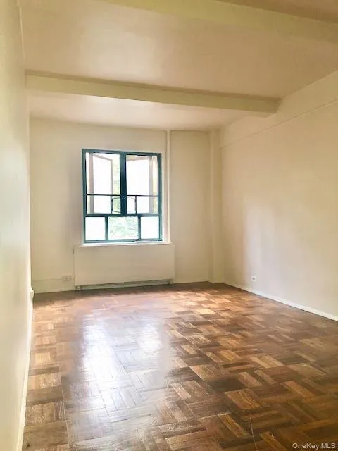 Unfurnished room with beamed ceiling and radiator Unfurnished room with beamed ceiling and radiator