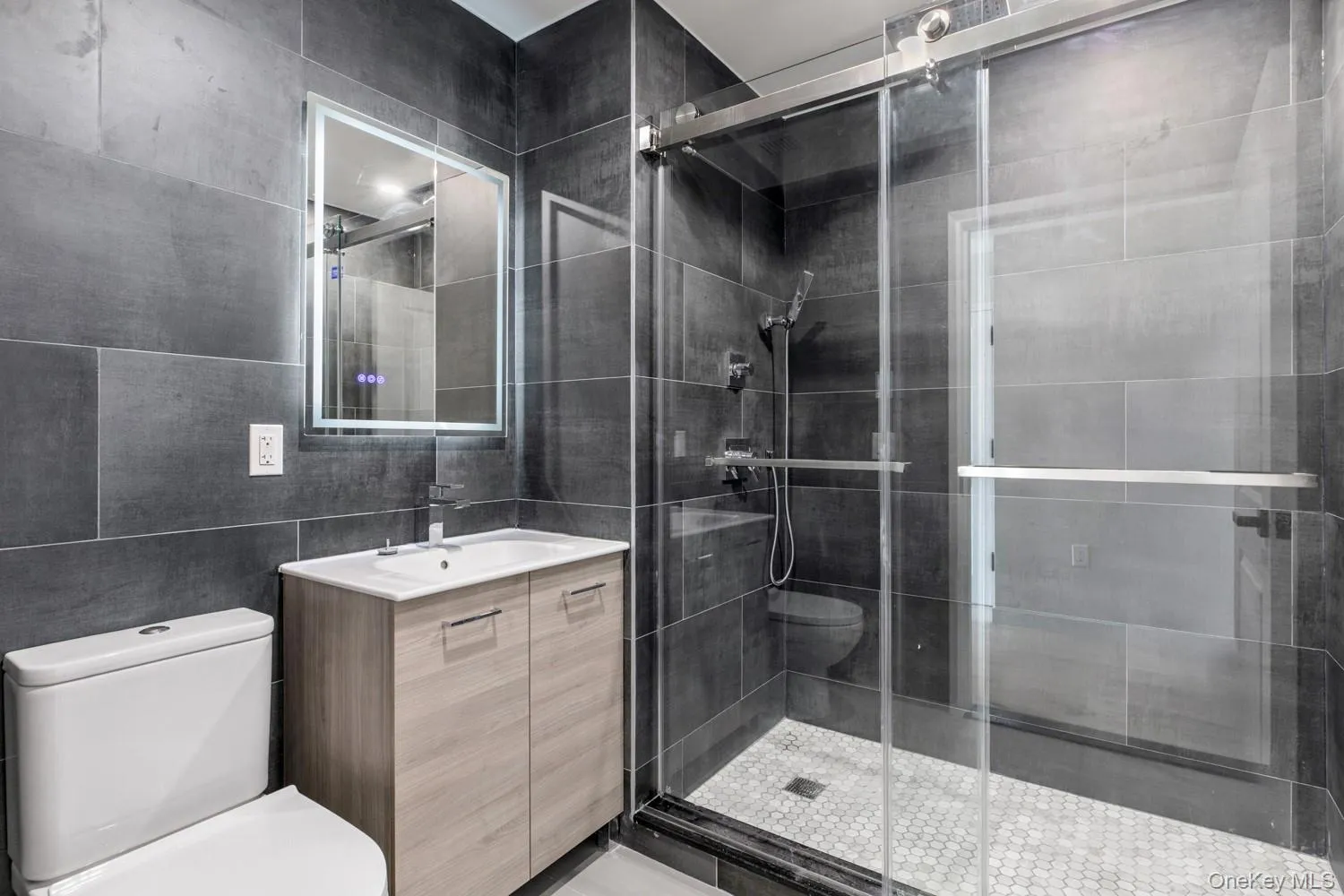 Full bath featuring tile walls, a stall shower, and vanity Full bath featuring tile walls, a stall shower, and vanity