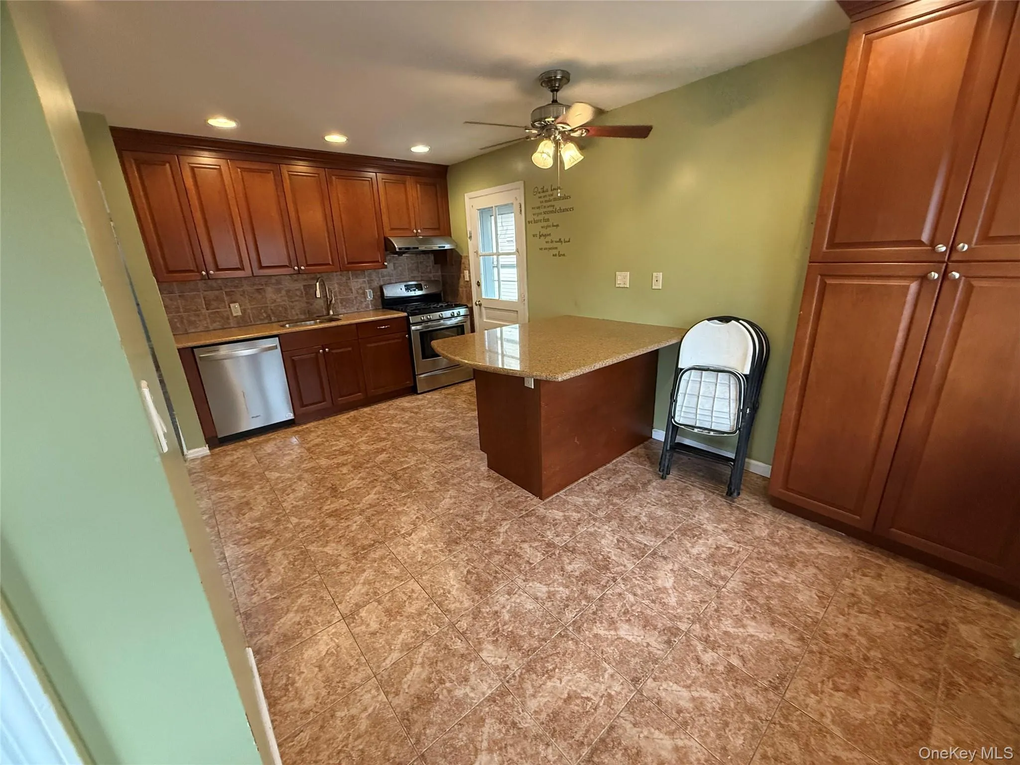 Kitchen with decorative backsplash, stainless steel appliances, recessed lighting, a peninsula, and light stone countertops Kitchen with decorative backsplash, stainless steel appliances, recessed lighting, a peninsula, and light stone countertops