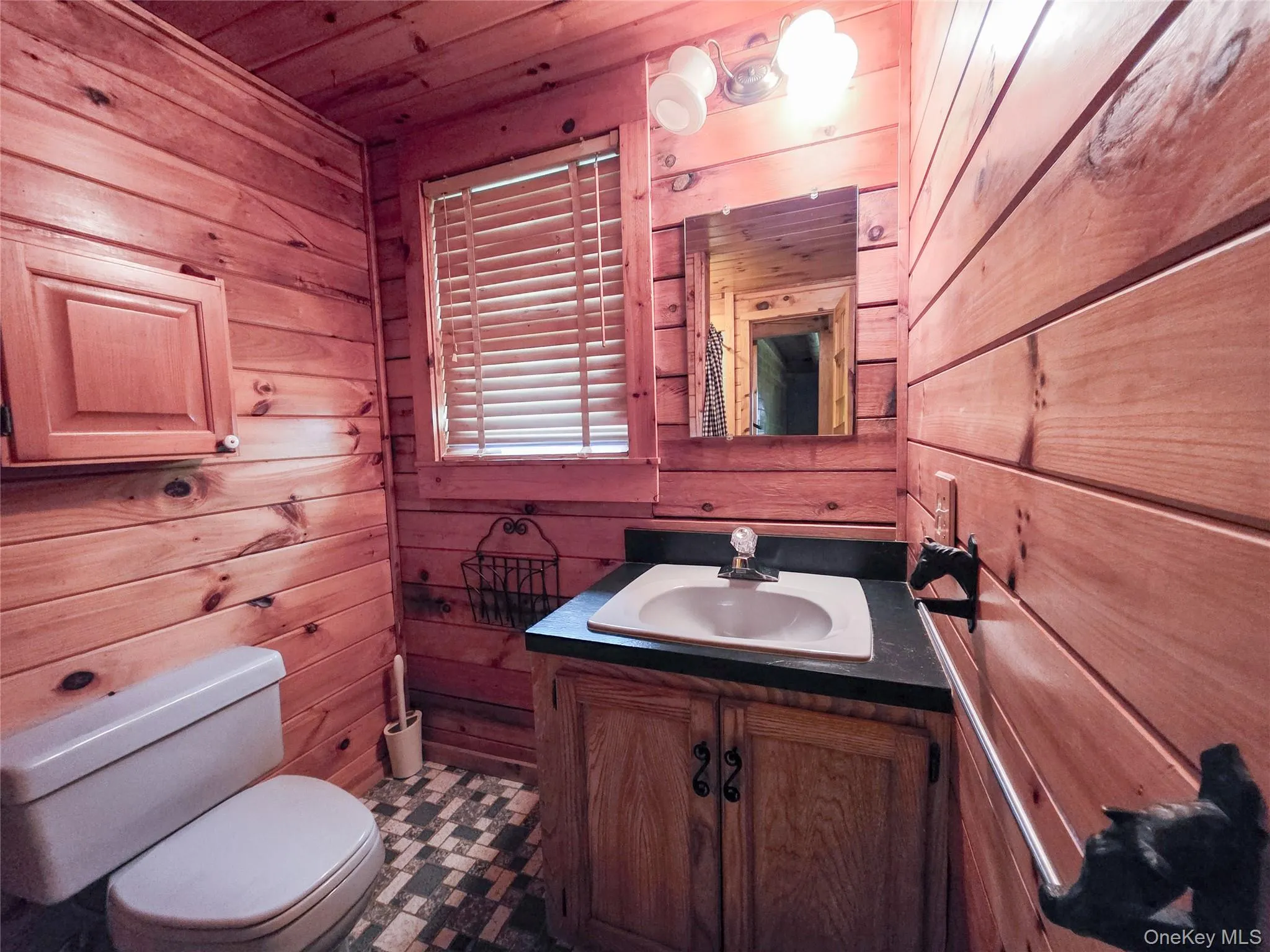 Half bath featuring wooden walls, vanity, and wooden ceiling Half bath featuring wooden walls, vanity, and wooden ceiling