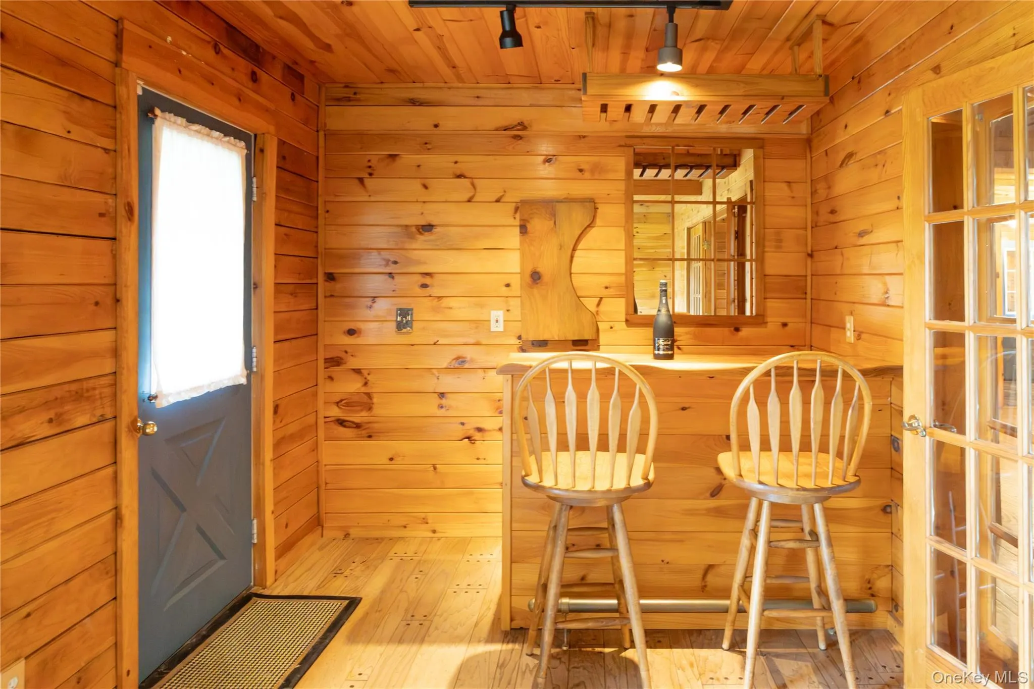 Indoor dry bar with hardwood / wood-style floors, wooden walls, and wood ceiling Indoor dry bar with hardwood / wood-style floors, wooden walls, and wood ceiling