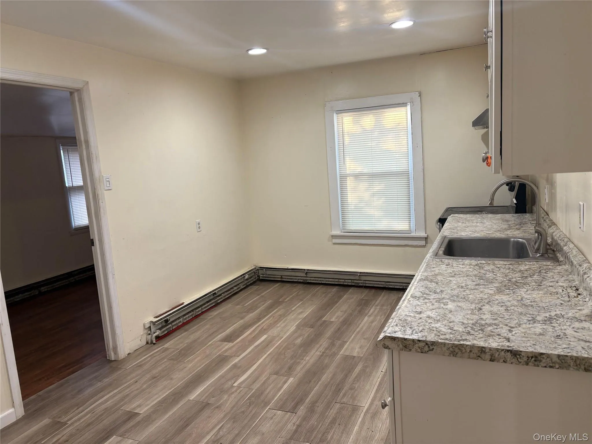 Kitchen with light countertops, dark wood-style flooring, recessed lighting, baseboard heating, and range Kitchen with light countertops, dark wood-style flooring, recessed lighting, baseboard heating, and range