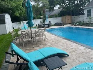 View of pool with a patio, a shed, a fenced backyard, and outdoor dining space View of pool with a patio, a shed, a fenced backyard, and outdoor dining space