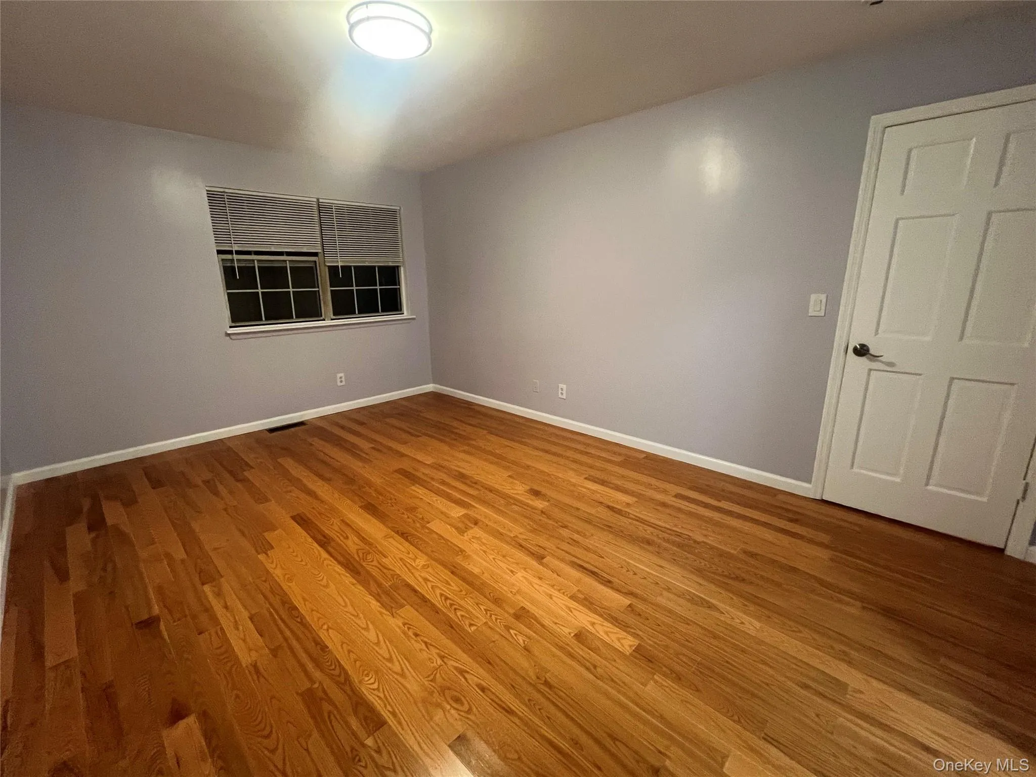 Empty room with wood finished floors and baseboards Empty room with wood finished floors and baseboards