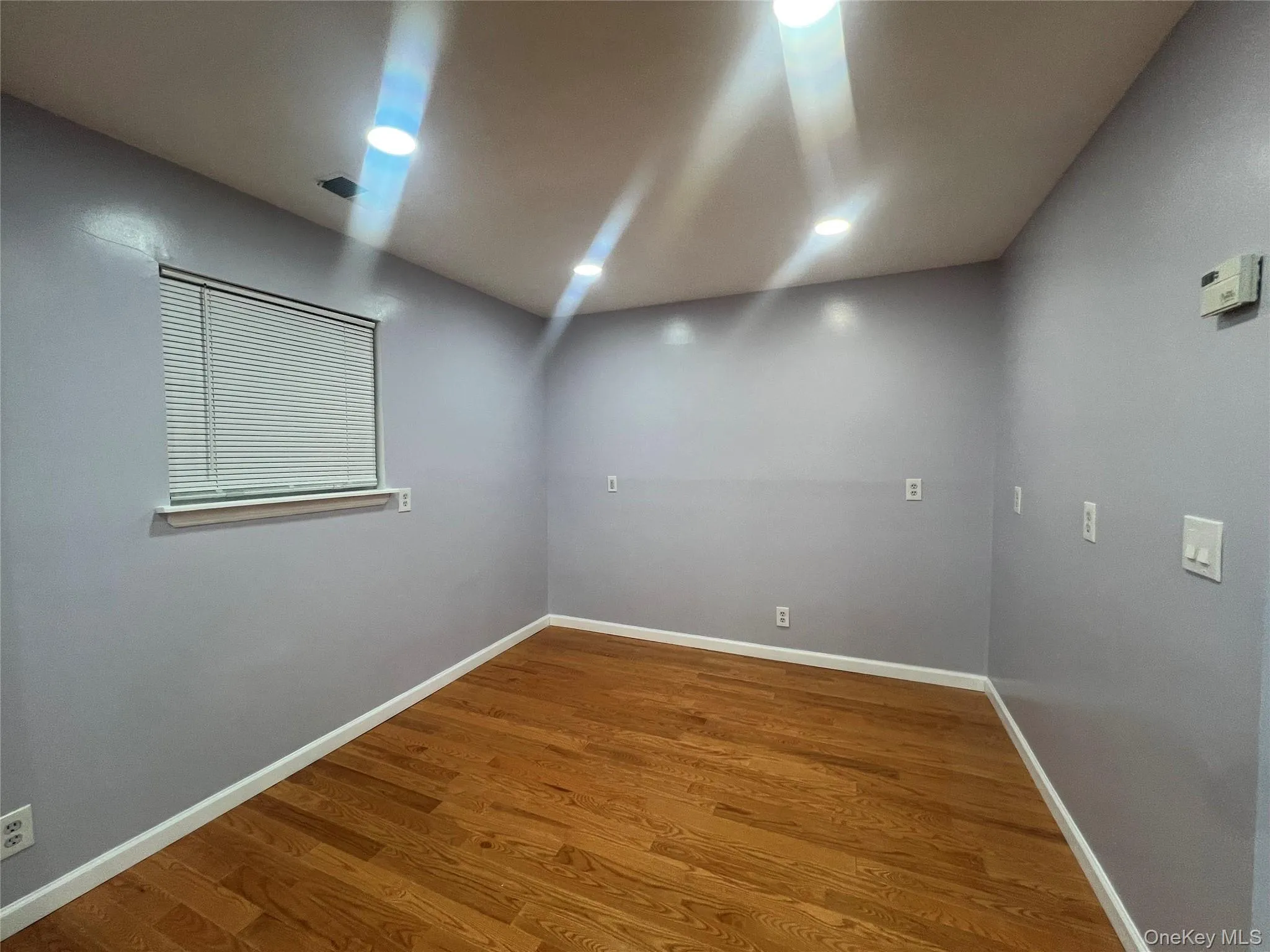 Empty room with wood finished floors and recessed lighting Empty room with wood finished floors and recessed lighting