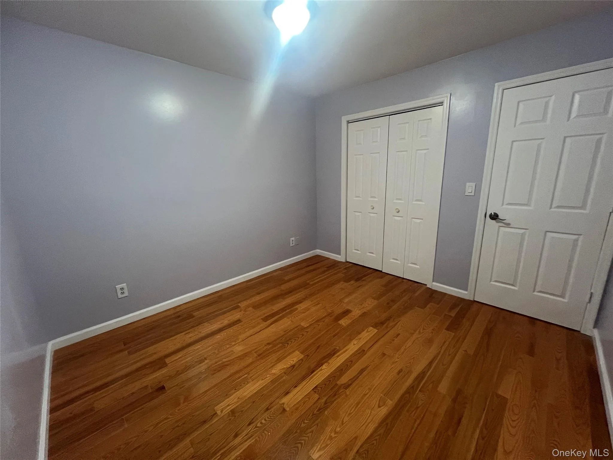 Unfurnished bedroom with wood finished floors and a closet Unfurnished bedroom with wood finished floors and a closet