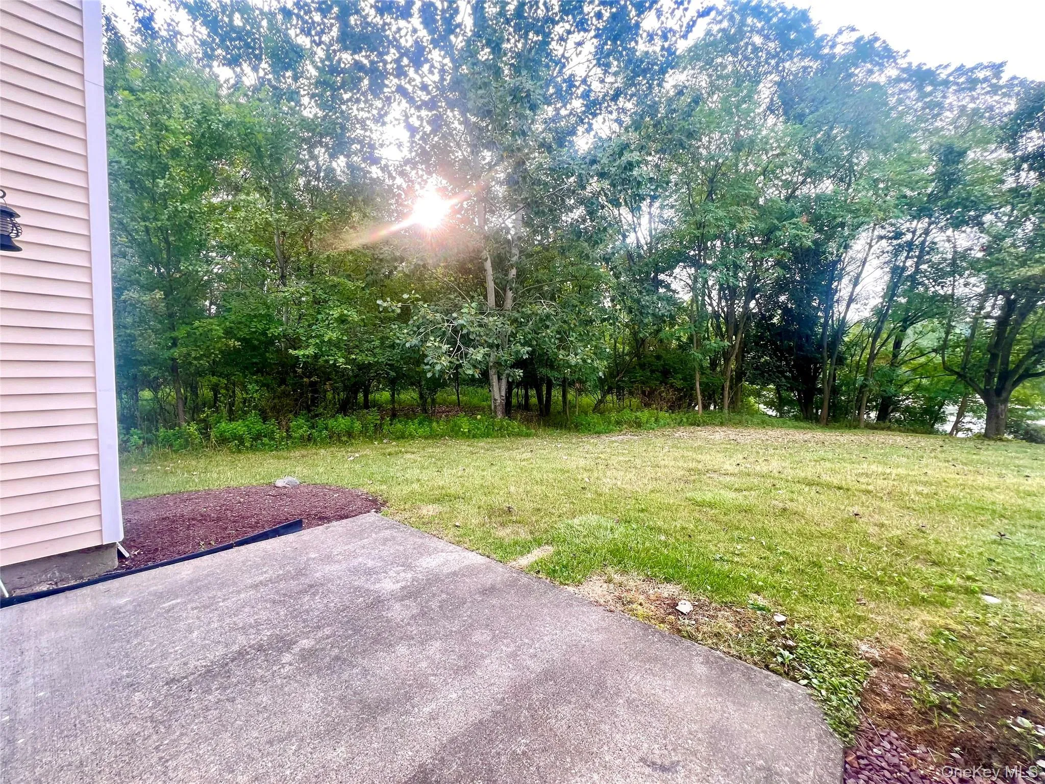View of grassy yard featuring a patio area View of grassy yard featuring a patio area