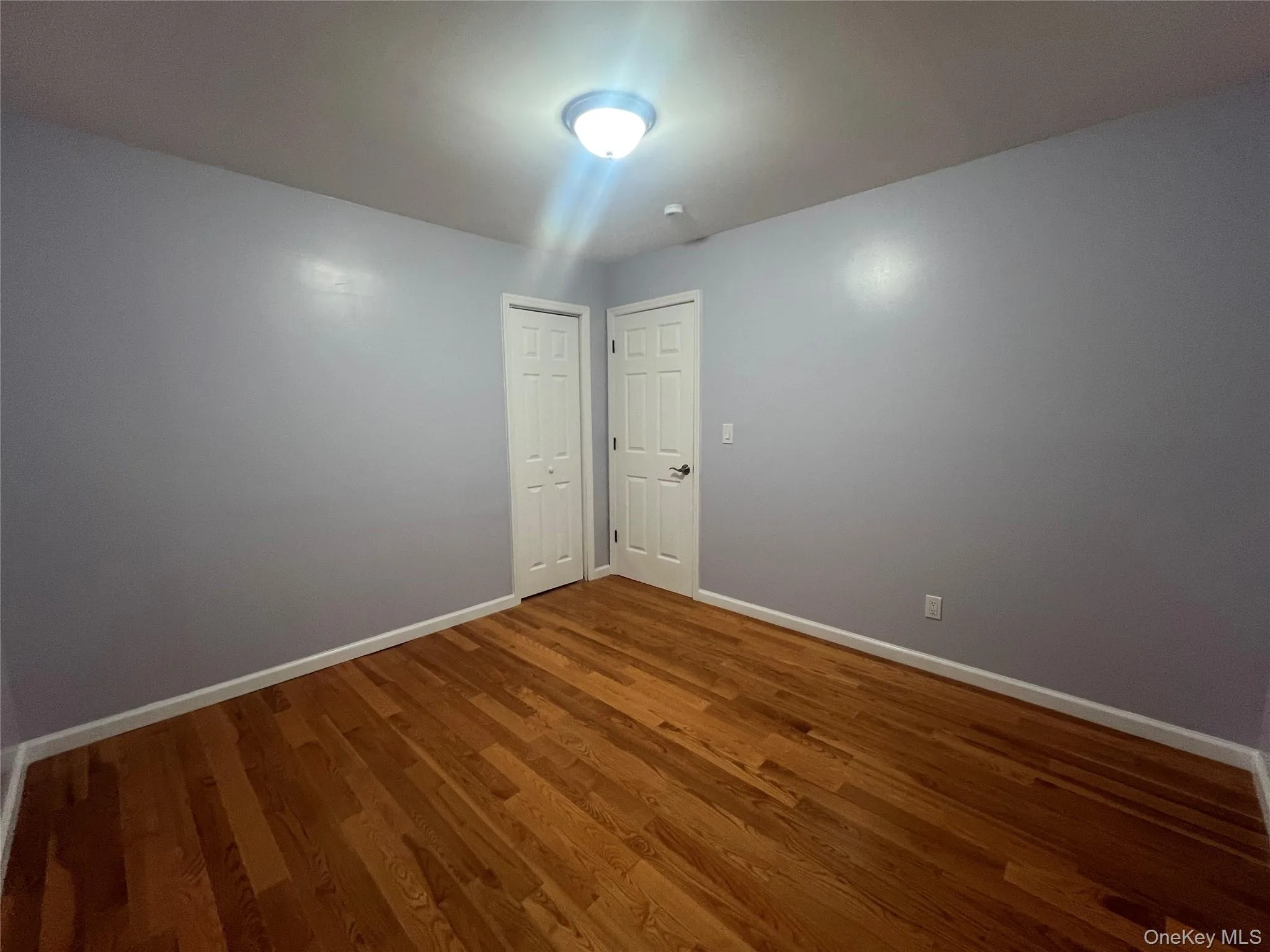 Spare room with wood finished floors and baseboards Spare room with wood finished floors and baseboards