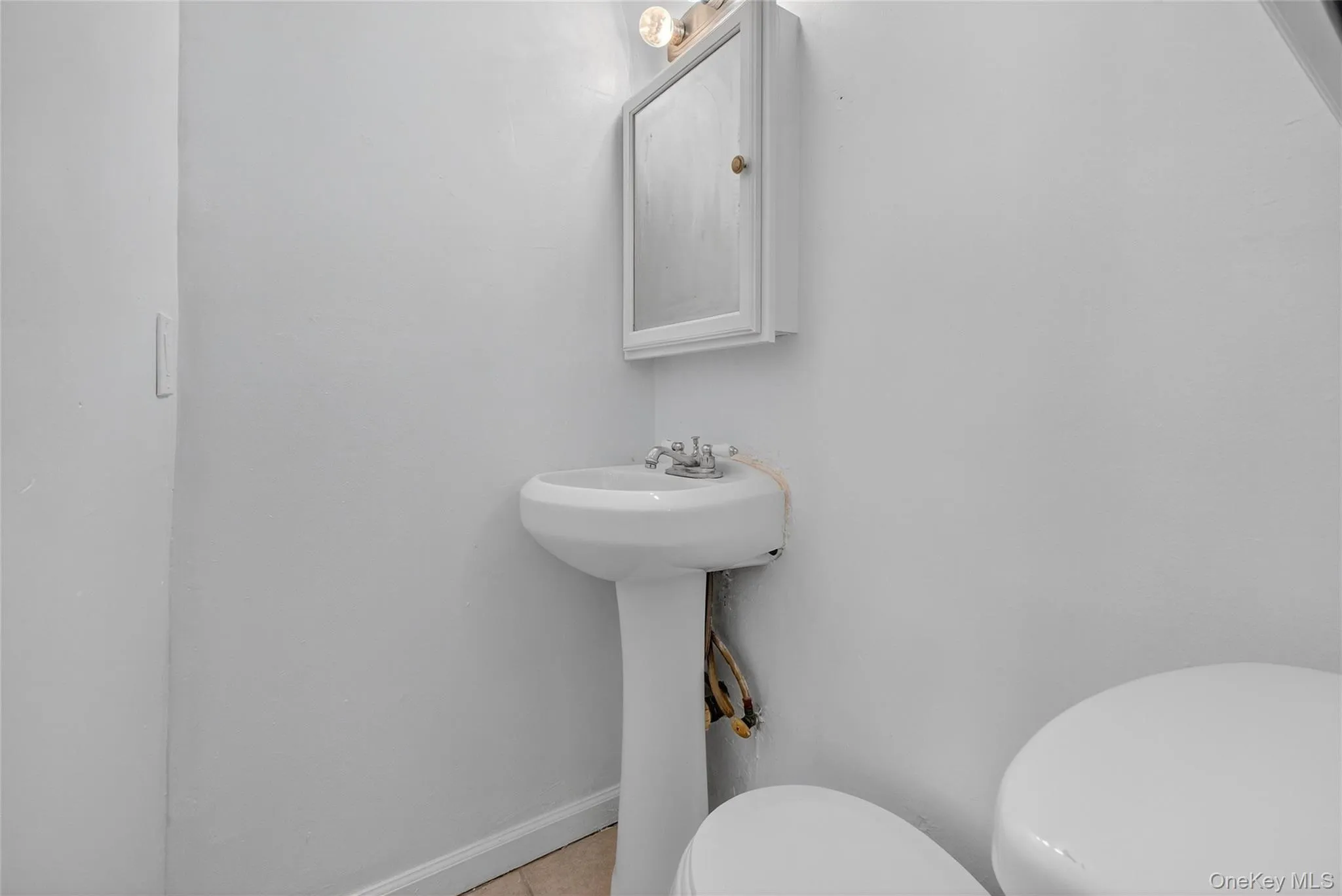 Half bath featuring toilet and light tile patterned flooring Half bath featuring toilet and light tile patterned flooring