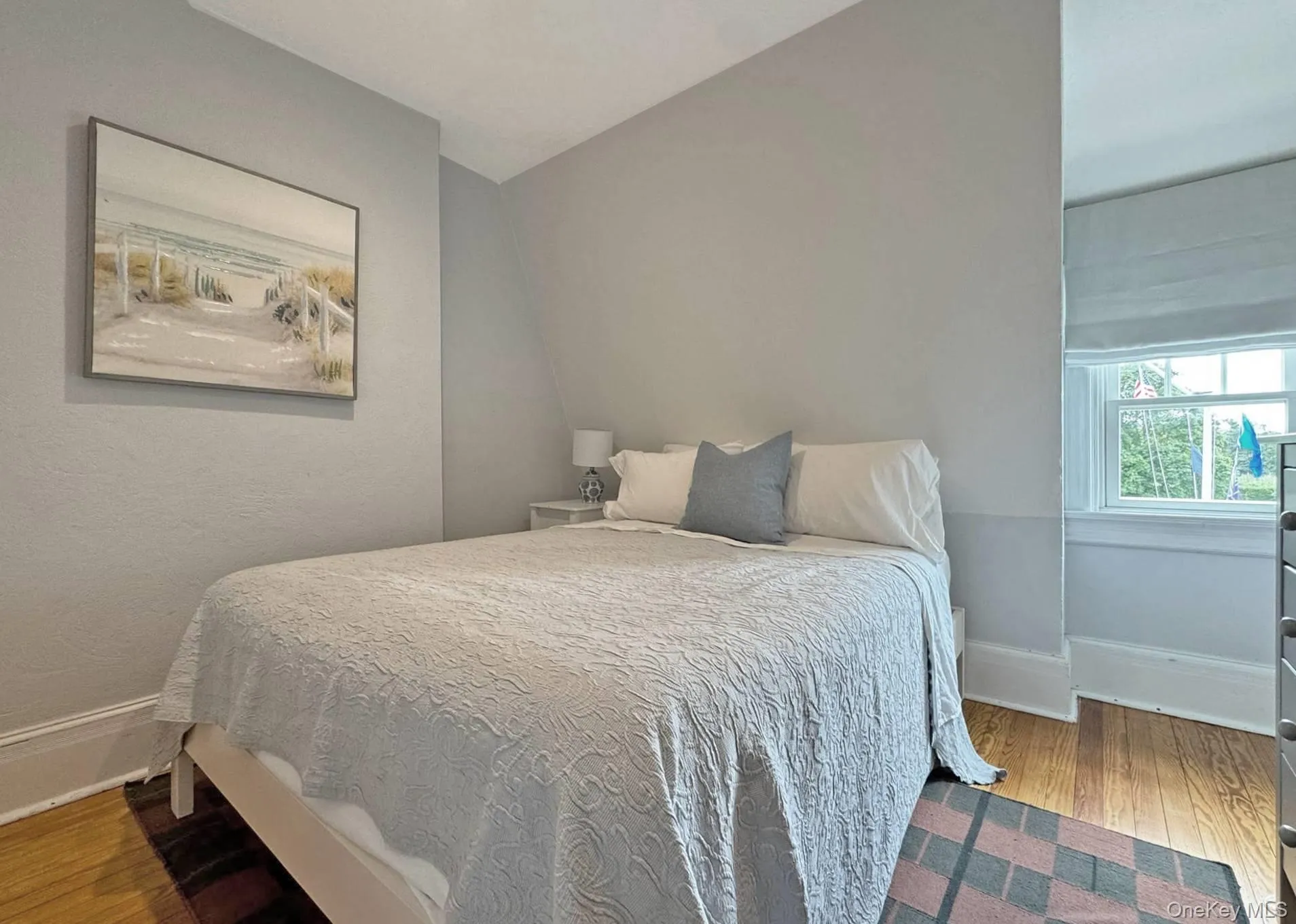 Bedroom featuring light wood finished floors and lofted ceiling Bedroom featuring light wood finished floors and lofted ceiling