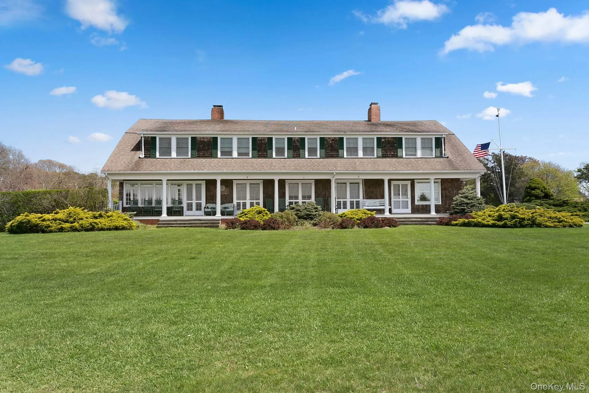 Back of property with a porch, a chimney, and a lawn Back of property with a porch, a chimney, and a lawn