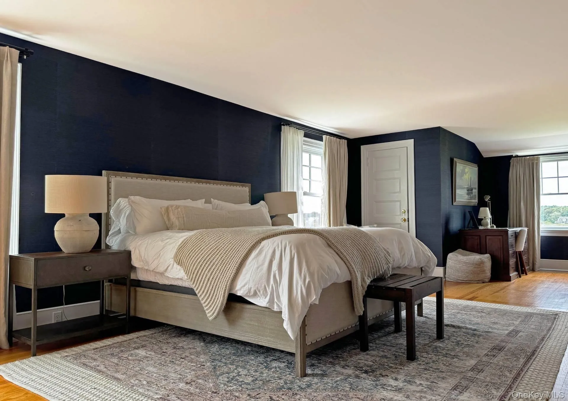 Bedroom featuring light wood-type flooring and multiple windows Bedroom featuring light wood-type flooring and multiple windows