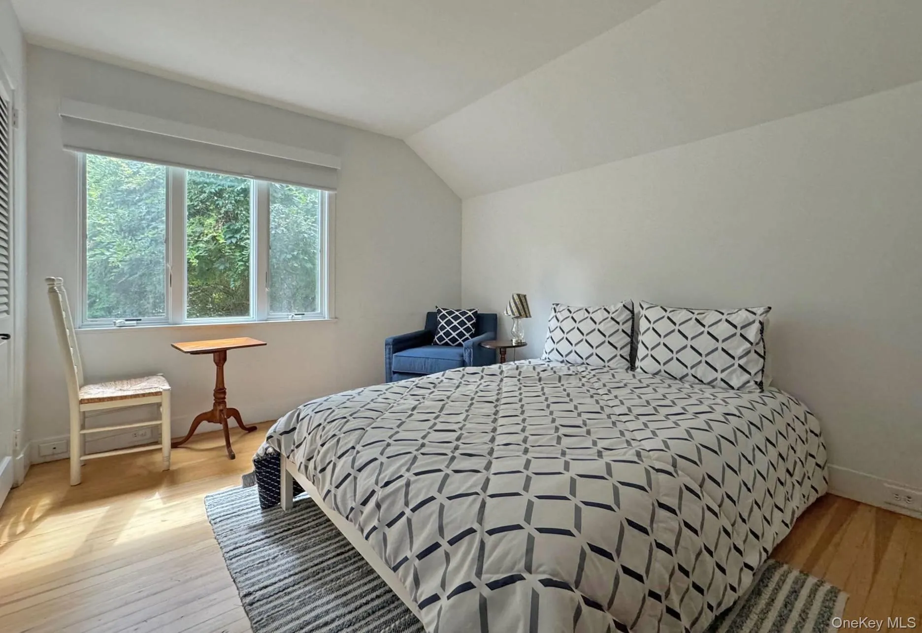 Bedroom featuring light wood-style floors and vaulted ceiling Bedroom featuring light wood-style floors and vaulted ceiling