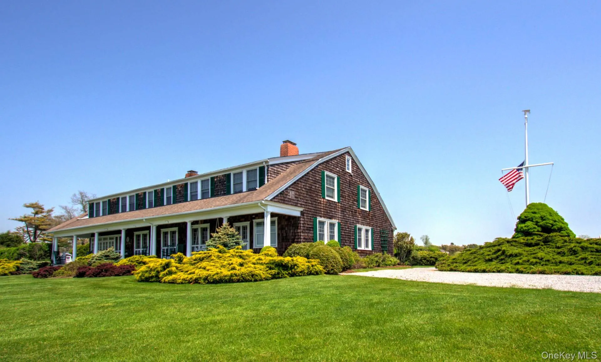 View of front facade featuring a chimney, a porch, and a front yard View of front facade featuring a chimney, a porch, and a front yard