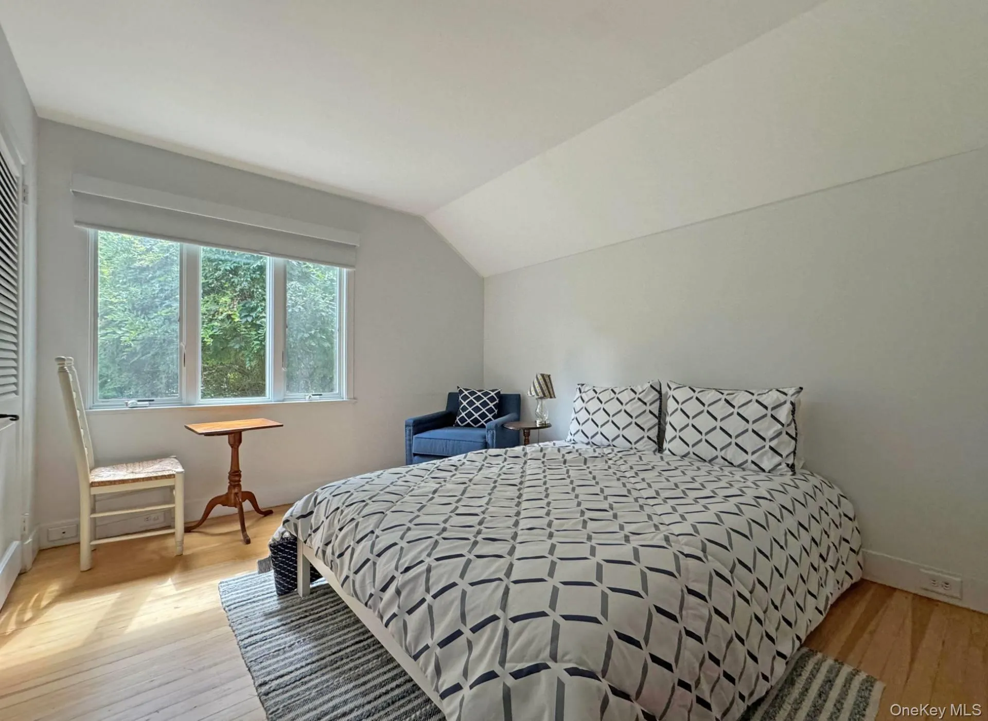 Bedroom featuring light wood-style floors and lofted ceiling Bedroom featuring light wood-style floors and lofted ceiling
