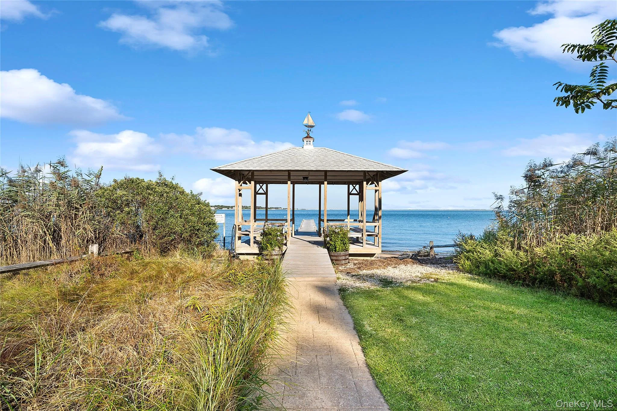 Dock area featuring a gazebo, a water view, and a yard Dock area featuring a gazebo, a water view, and a yard