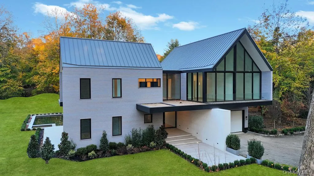 Rear view of property featuring a lawn, a metal roof, and a balcony Rear view of property featuring a lawn, a metal roof, and a balcony