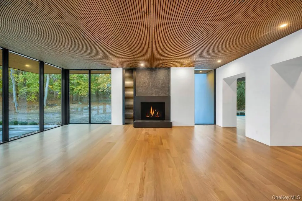 Unfurnished living room featuring expansive windows, a fireplace, wood finished floors, and wood ceiling Unfurnished living room featuring expansive windows, a fireplace, wood finished floors, and wood ceiling
